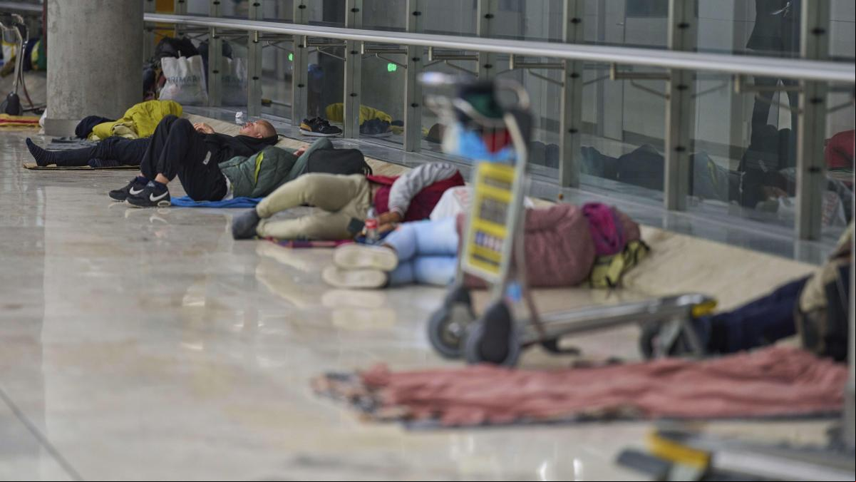 Las personas sin techo se trasladan al parking de la T-4 por los controles de  en Barajas